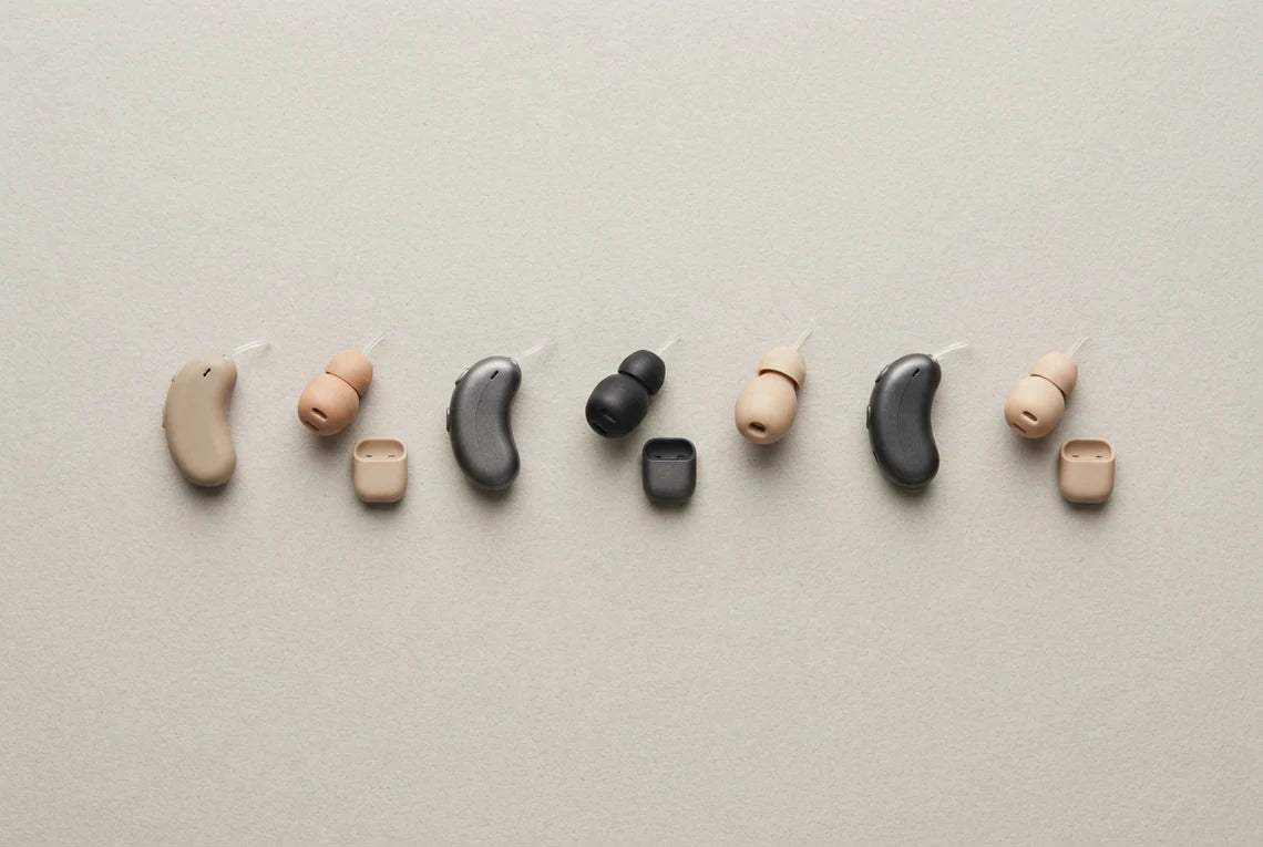 Seven invisible hearing aids laid out side by side for comparison testing