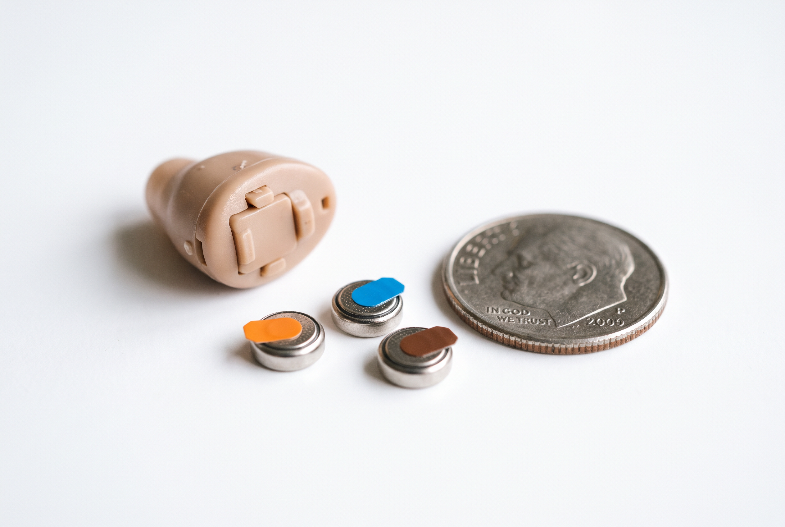 A completely-in-canal hearing aid beside zinc-air batteries